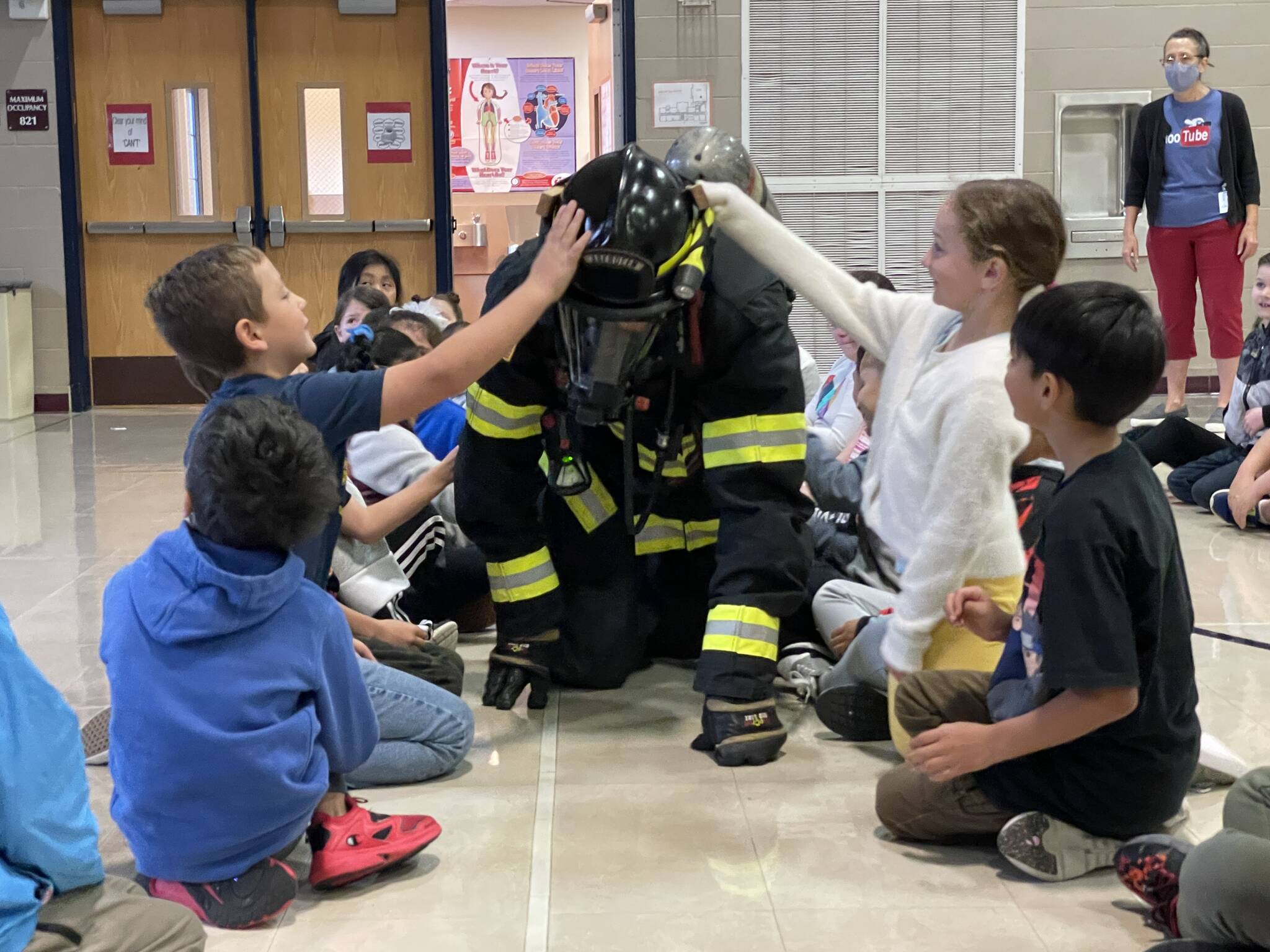 Firefighter/EMT James Freed crawls in full kit through a group of second graders at McDermoth Elementary School during a Fire Prevention Week presentation from the Aberdeen Fire Department on Monday.
Michael S. Lockett | The Daily World