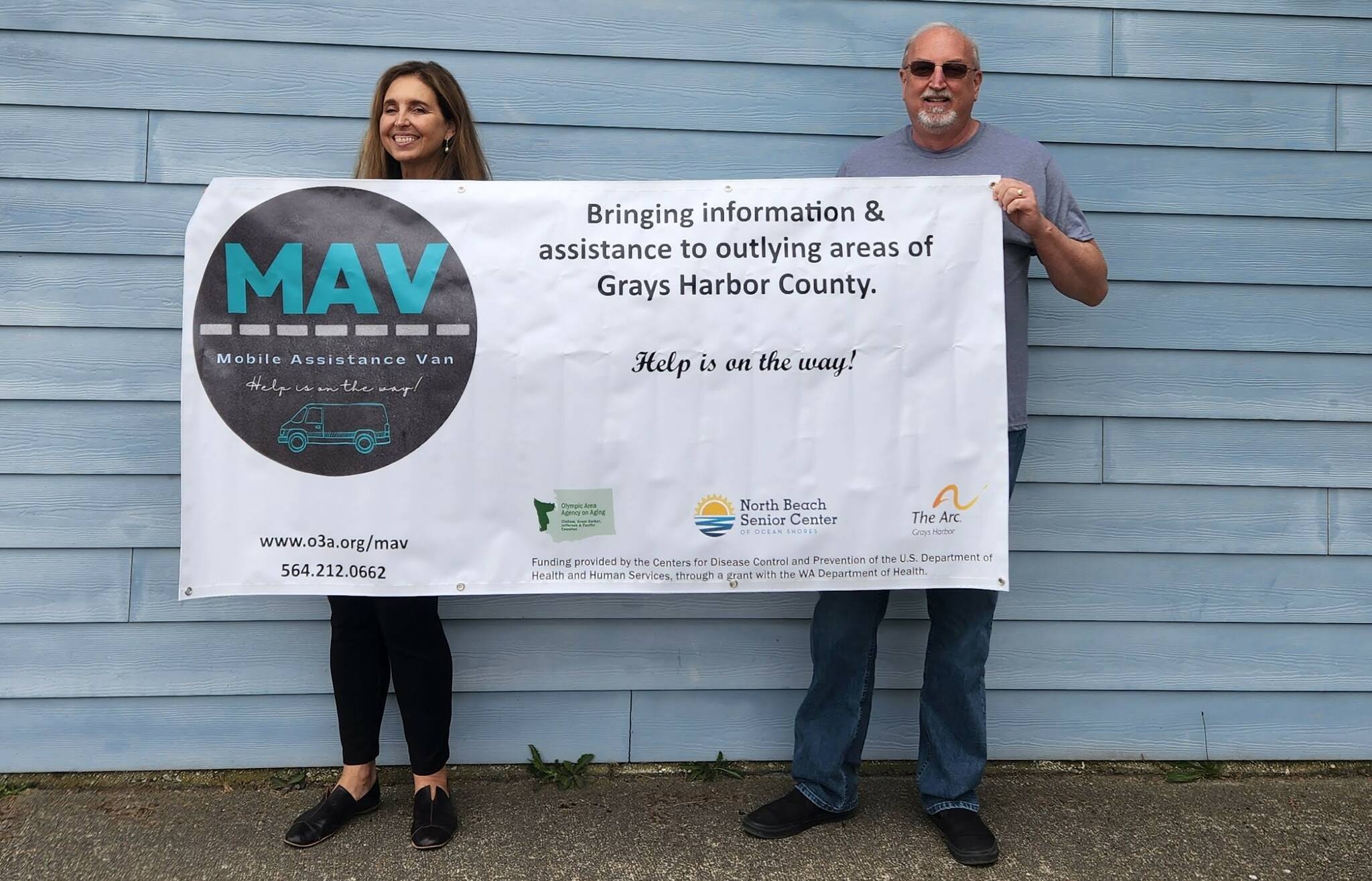 (Courtesy of Michelle Fogus) Jeff Moyer, right, executive director of the North Beach Senior Center, and Laura Cepoi, executive director of the Olympic Area Agency on Aging, display the banner for the new MAV mobile service project.