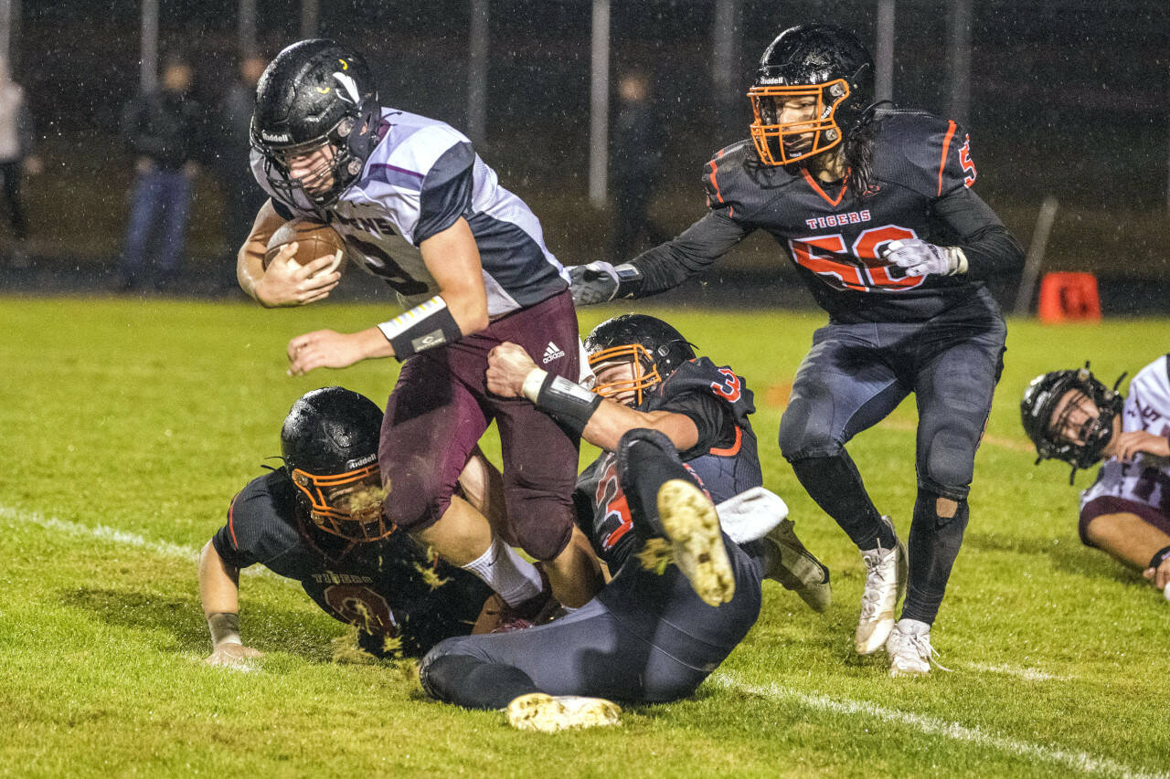JARED WENZELBURGER | THE CHRONICLE Napvine players swarm and make a tackle on Raymond-South Bend’s Austin Snodgrass after blocking a punt during the Ravens’ 54-0 loss Friday, in Napavine.