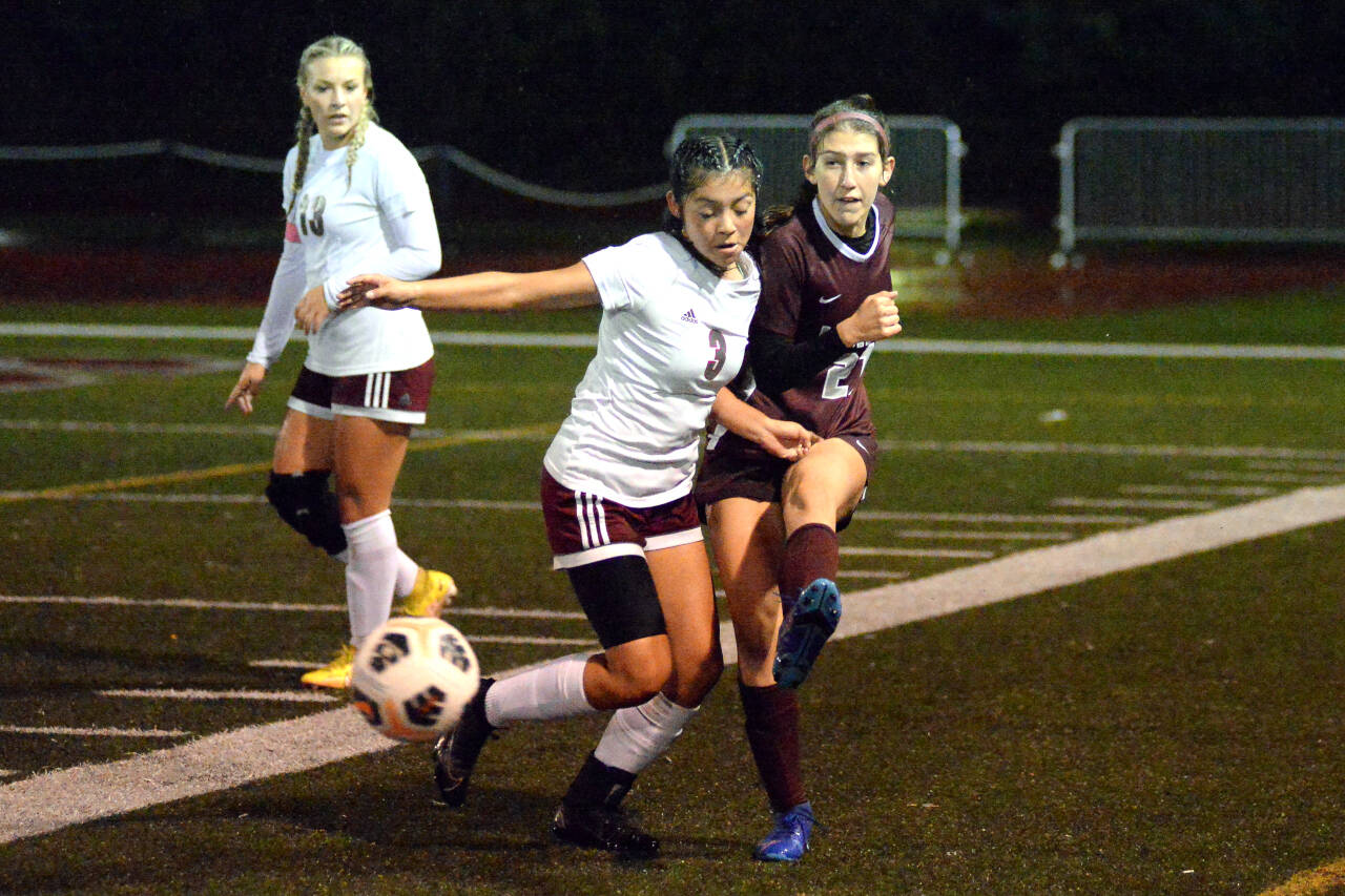 RYAN SPARKS | THE DAILY WORLD Montesano midfielder Belle Estrada, right, passes the ball while defended by WF West’s Daisy Medel (3) during the Bulldogs’ 4-3 win on Tuesday in Montesano. Estrada scored two second-half goals in the game.
