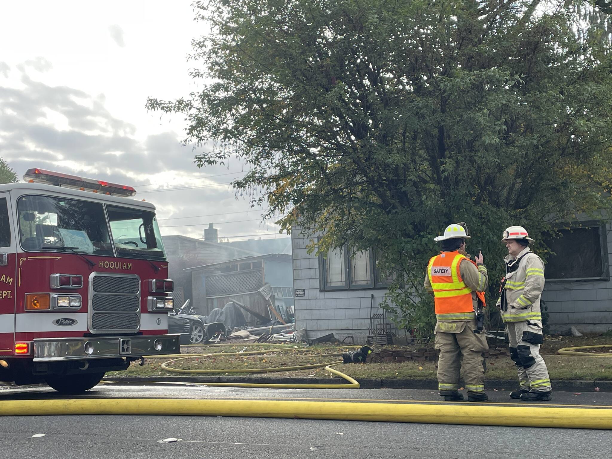 Firefighters confer during the tail end of a response to a fire in Hoquiam on Thursday. (Michael S. Lockett / The Daily World)