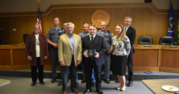 Allen Leister / The Daily World 
Grays Harbor Deputy Prosecutor Richard Fisher, (holding award) was presented with a Mothers Against Drunk Driving Leadership Award by David Maughan (left of Fisher), at the Grays Harbor Large Commissioners Meeting Room on Thursday, Oct. 27, in Montesano.