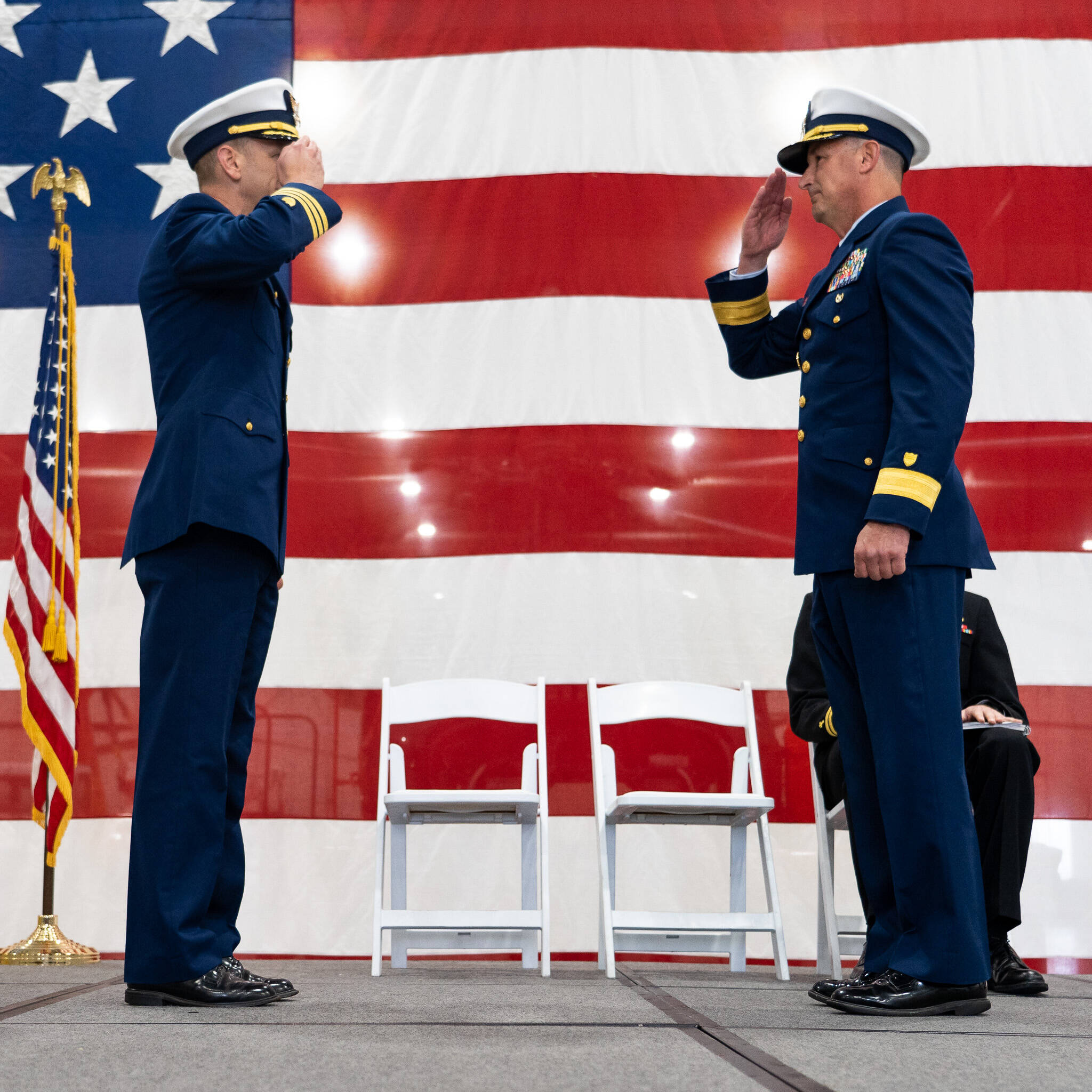 Cmdr. Todd Wimmer, the commanding officer of Base Astoria, salutes Rear Adm. Jon Hickey, the Director of Operational Logistics, during an establishment ceremony in Warrenton, Oregon, to formally establish Coast Guard Base Astoria Oct. 26. (Petty Officer 1st Class Travis Magee / USCG)