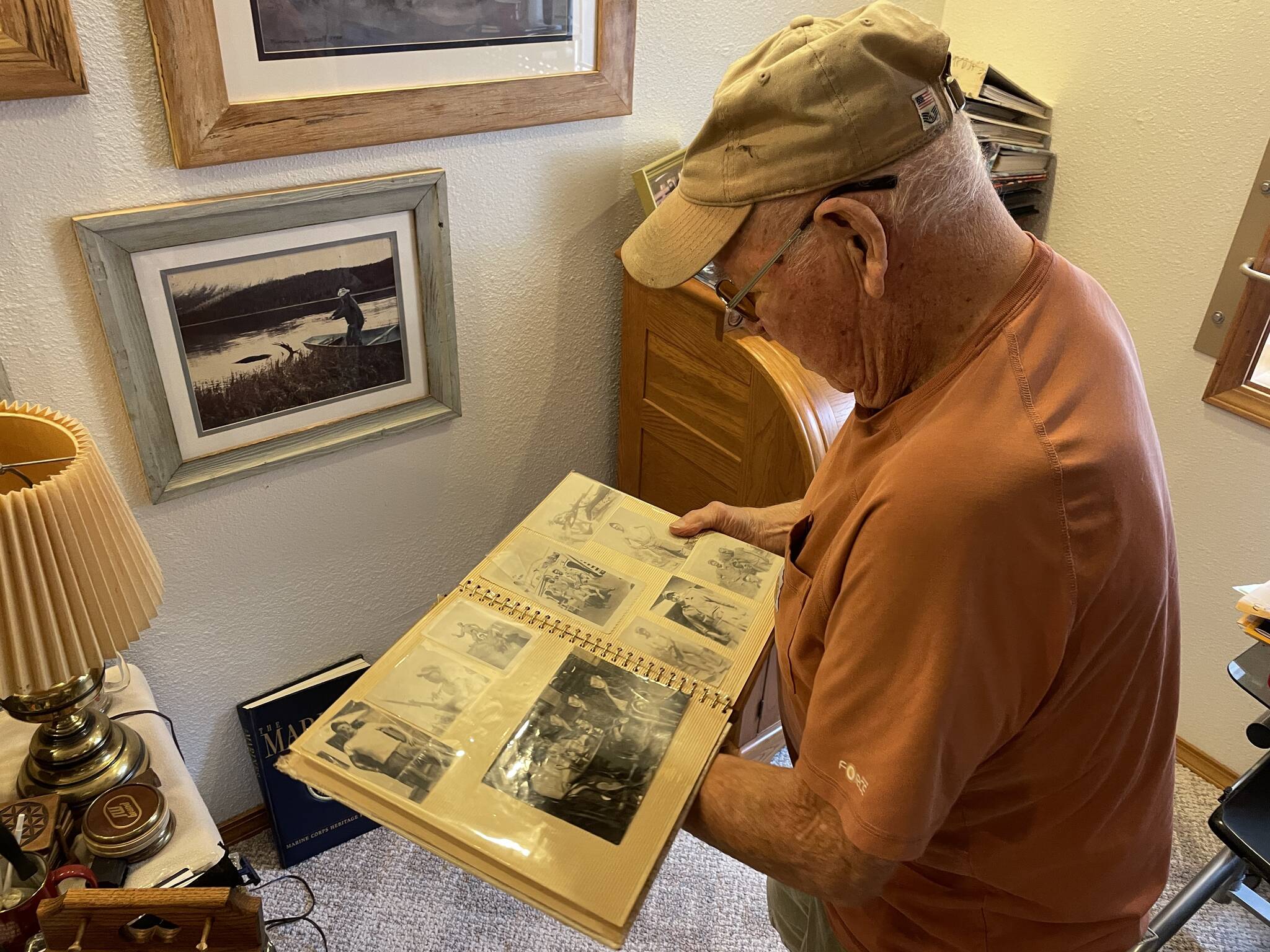 Irv Stephens looks at a book containing photos from his time in the Marine Corps during the Korean War on Nov. 2. (Michael S. Lockett / The Daily World)