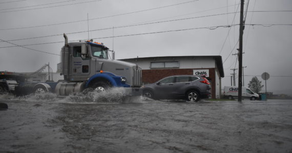 Stormwater filled streets Friday afternoon with several inches of water in some places, slowing traffic. (Clayton Franke / The Daily World)