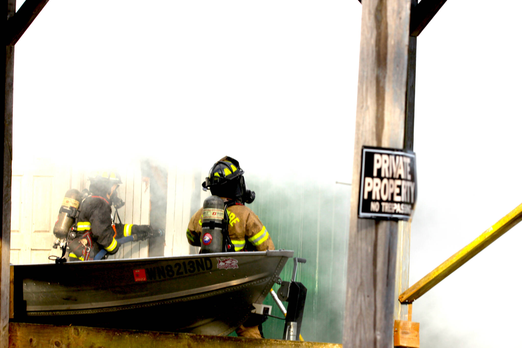 Firefighters peer through heavy smoke at a structure fire in Elma on Nov. 15. (Michael S. Lockett / The Daily World)