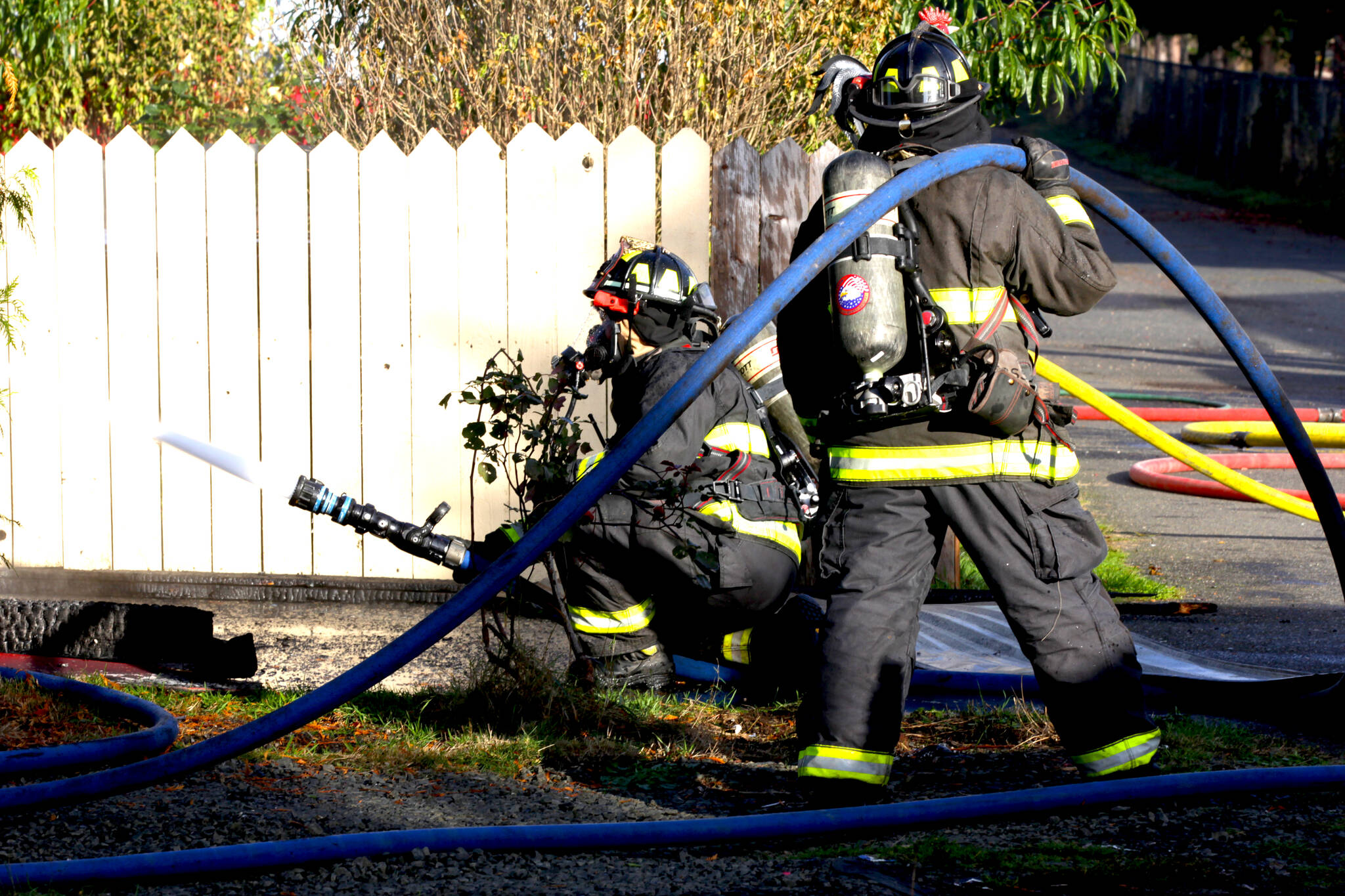 Firefighters spray down a structure fire in Elma on Nov. 15. (Michael S. Lockett / The Daily World)