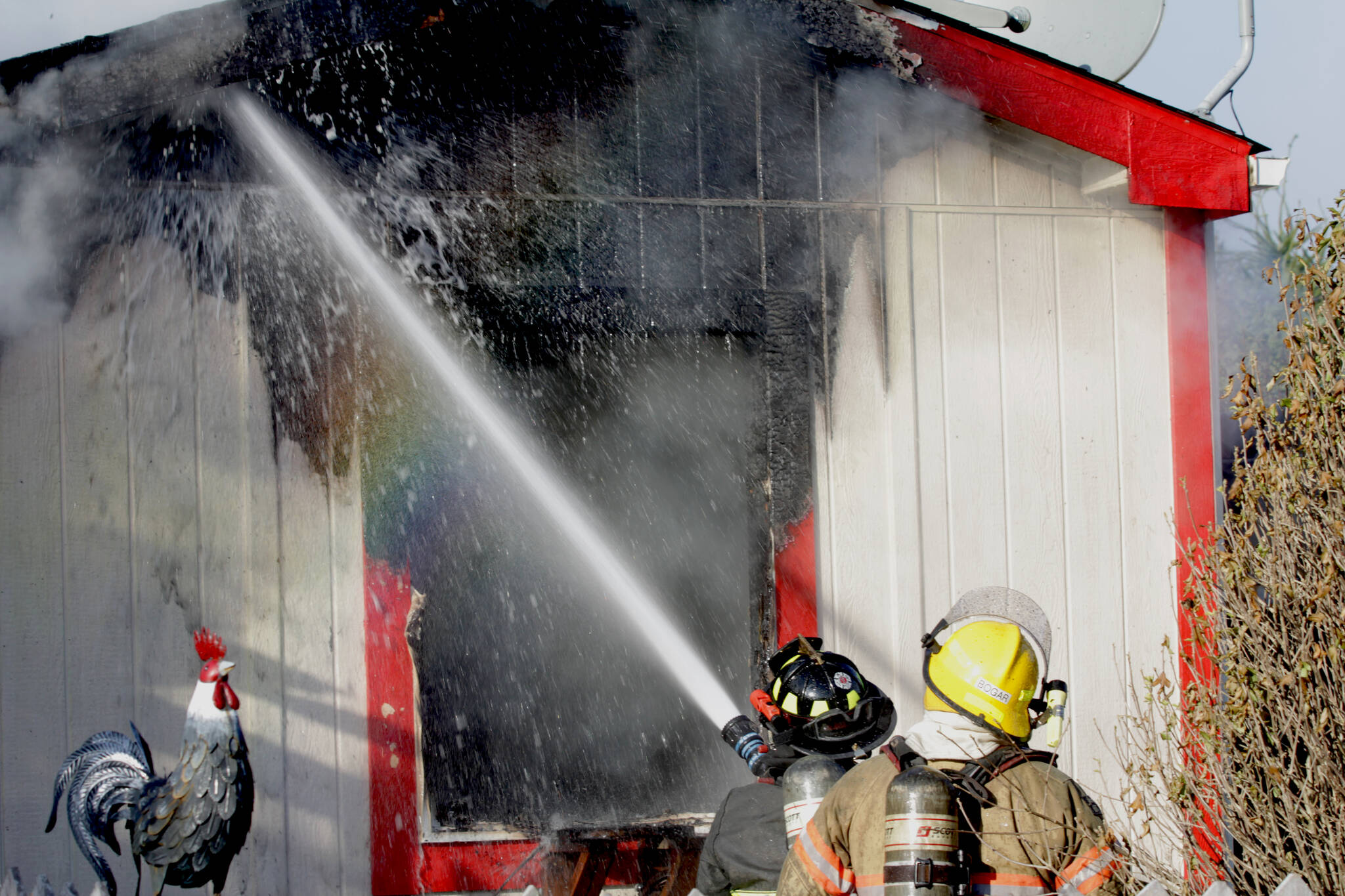 Michael S. Lockett / The Daily World 
Firefighters spray down a structure fire in Elma on Nov. 15.