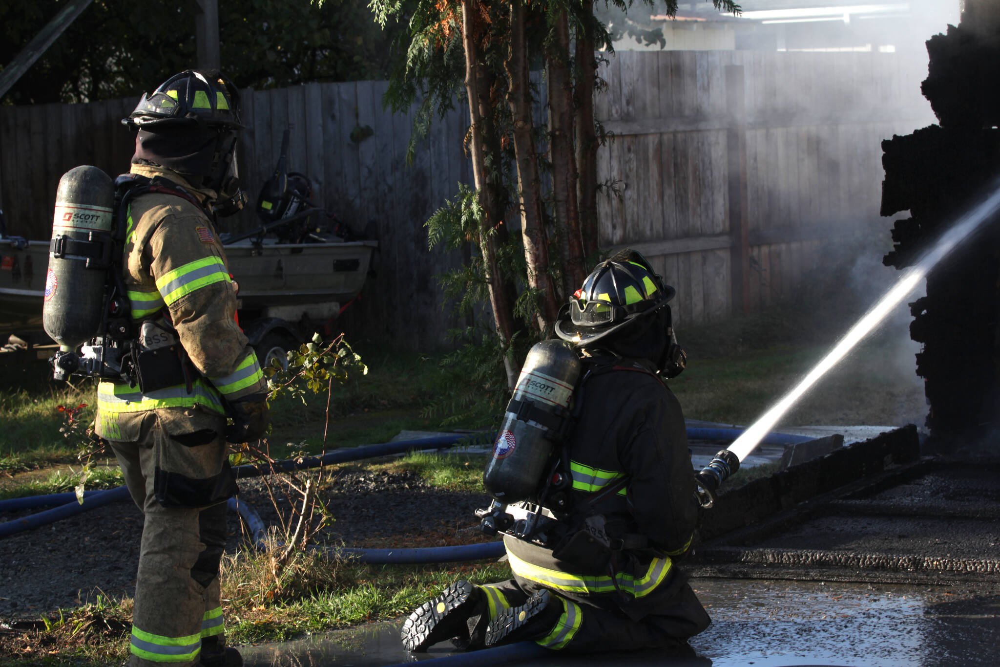 Firefighters spray down a structure fire in Elma on Nov. 15. (Michael S. Lockett / The Daily World)