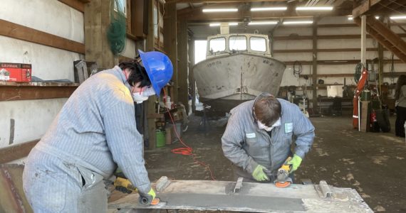 Michael S. Lockett / The Daily World 
Evan Brockhoff and Logan Slosson, students with the Ocosta High School’s Maritime afterschool program, buff out a deckplate as part of a boat restoration on Nov. 9.
