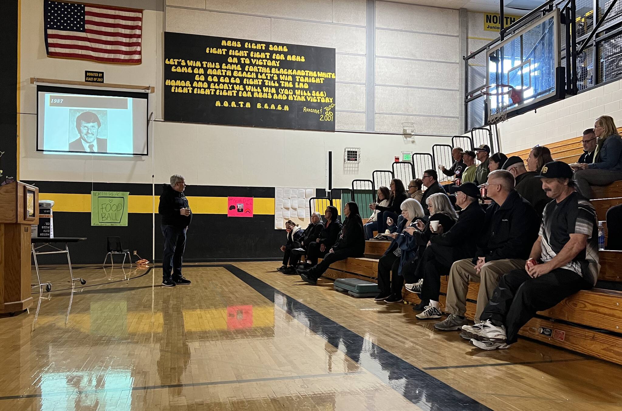 Former North Beach High School students gathered at the school Saturday to share memories of former principal Mike Duffy, who passed away last month. Duffy's picture is displayed on the projector. (Clayton Franke / The Daily World)