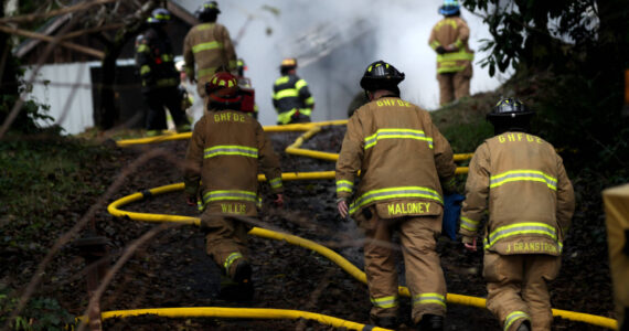 Michael S. Lockett / The Daily World
Firefighters climb toward a structure fire that broke out on Dec. 13 outside of Aberdeen.