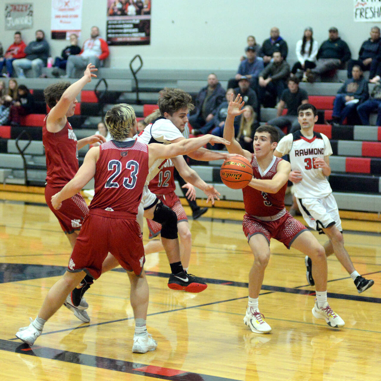 RYAN SPARKS | THE DAILY WORLD Hoquiam’s Justice Stankavich (23) and Owen McNeill (5) surround Raymond’s Skyler Hutson during the Grizzlies’ 80-47 win in the Raymond Holiday Classic on Tuesday at Raymond High School.