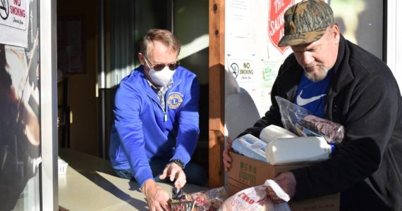 Clayton Franke / The Daily World
Volunteer Greg Johnstone, left, slides a box of food to Jerry Nelson Dec. 15 at the Aberdeen Salvation Army food pantry, 120 W. Wishkah St. The pantry serves roughly triple the amount of people it did one year ago.