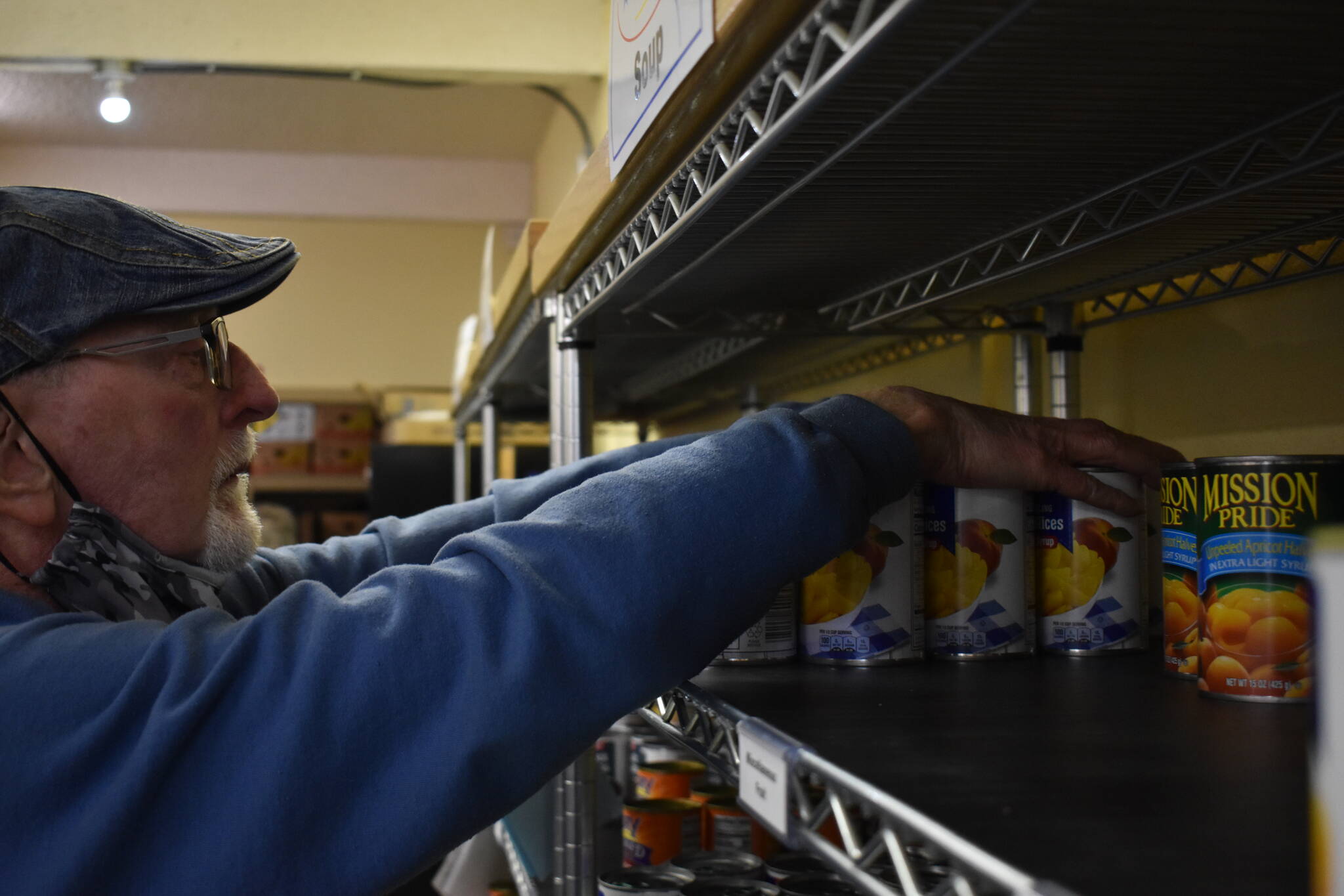 Clayton Franke / The Daily World 
Jerry Rugh, volunteer at the Ocean Shores Food Bank, organizes canned foods Dec. 15 at the pantry, which is located at 846 Anchor Avenue.