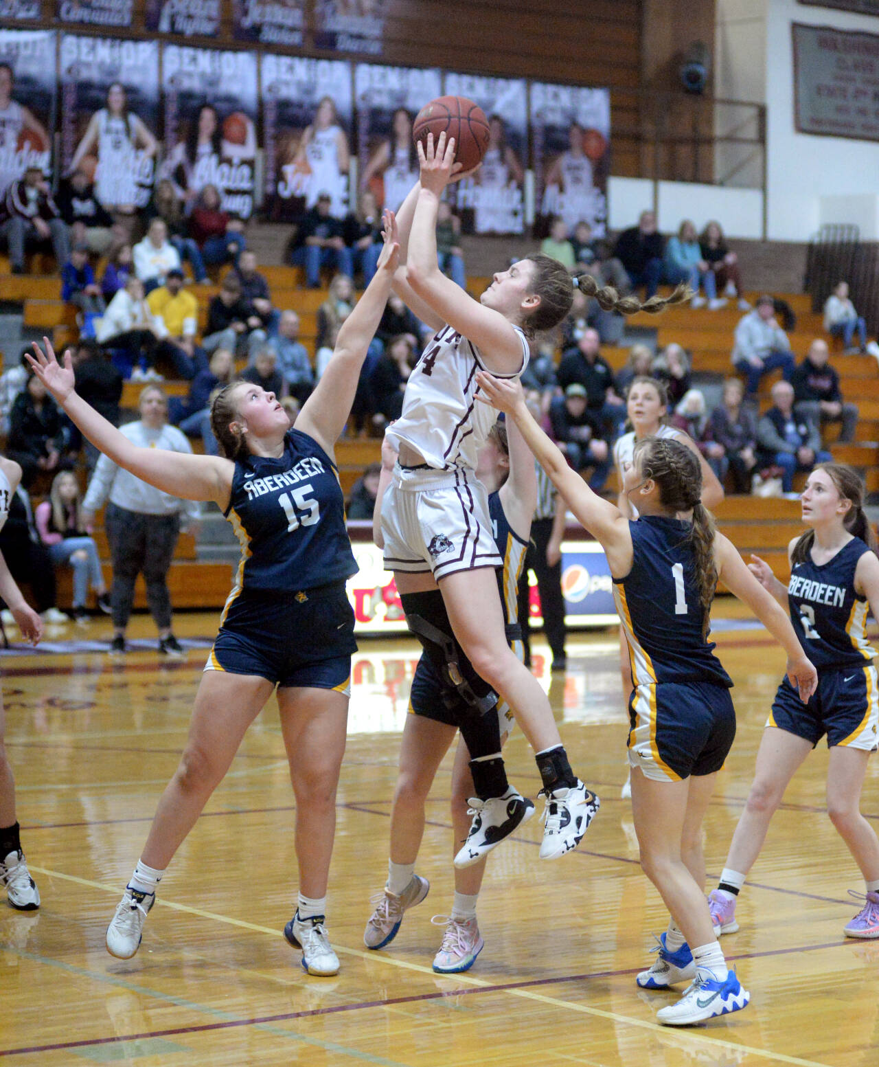 RYAN SPARKS | THE DAILY WORLD Montesano forward McKynnlie Dalan, middle, scores on a jump shot while defended by Aberdeen’s Alviyah Lamont (15) during the Bulldogs’ 59-25 victory on Wednesday in Montesano.