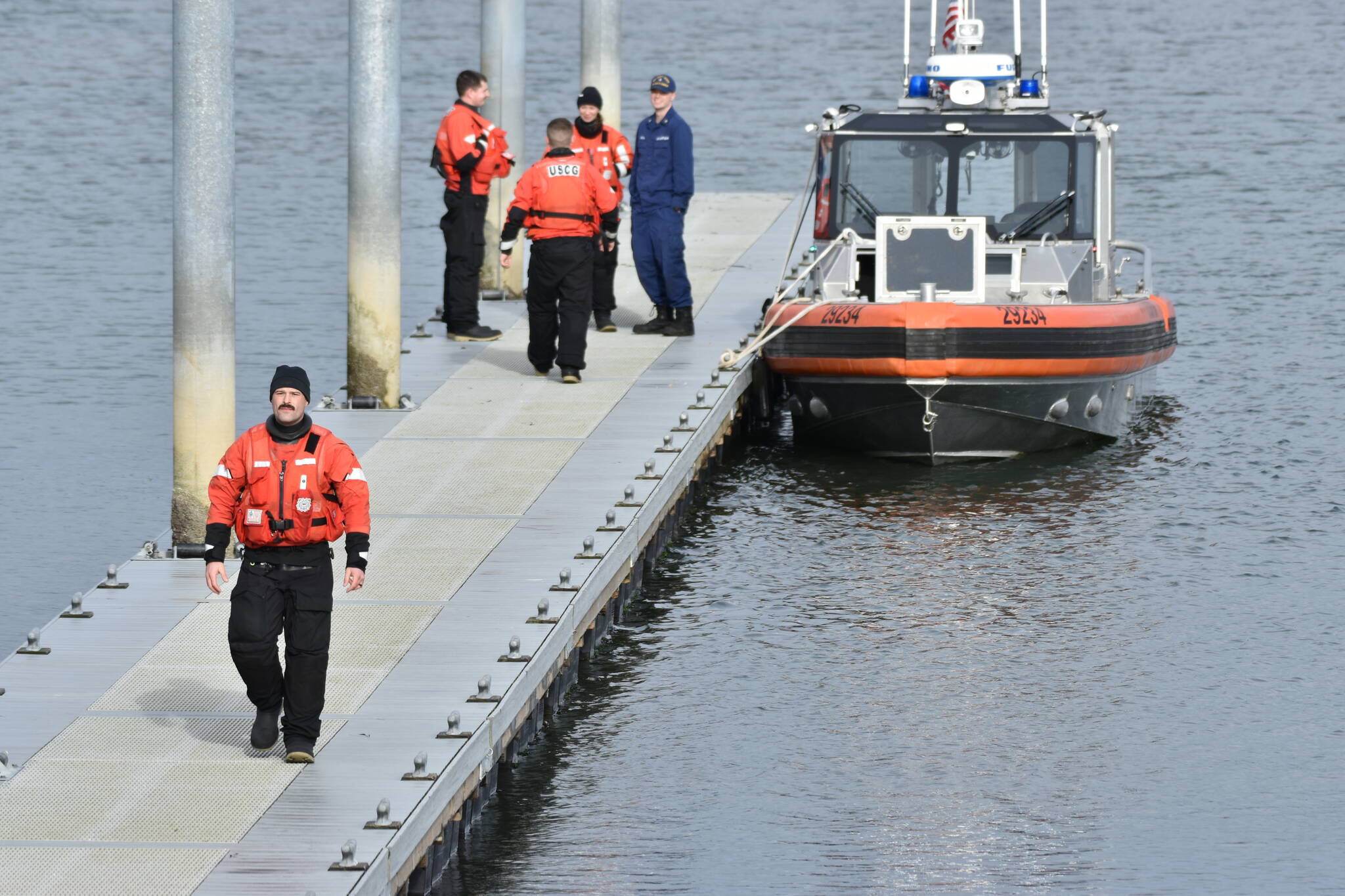 Coast Guard personnel stand on a pier near Tokeland after assisting in the recovery of two fishermen who capsized while pulling up a crab pot on Jan. 16. (Courtesy photo / Ezra McCampbell)