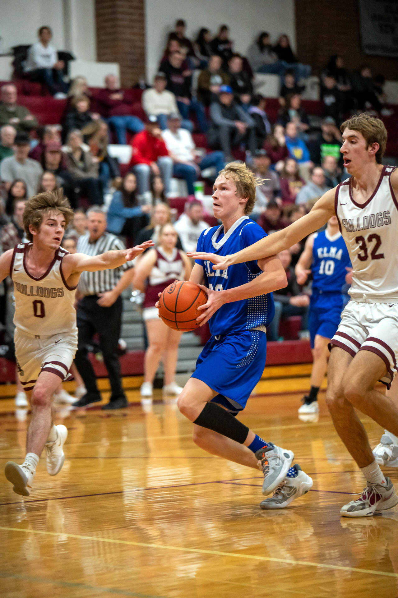 RYAN SPARKS | THE DAILY WORLD Elma guard Cason Seaberg drives to the basket against Montesano’s Trent Adams (0) and Soren Cobb during the Eagles’ 50-34 victory on Thursday in Montesano.