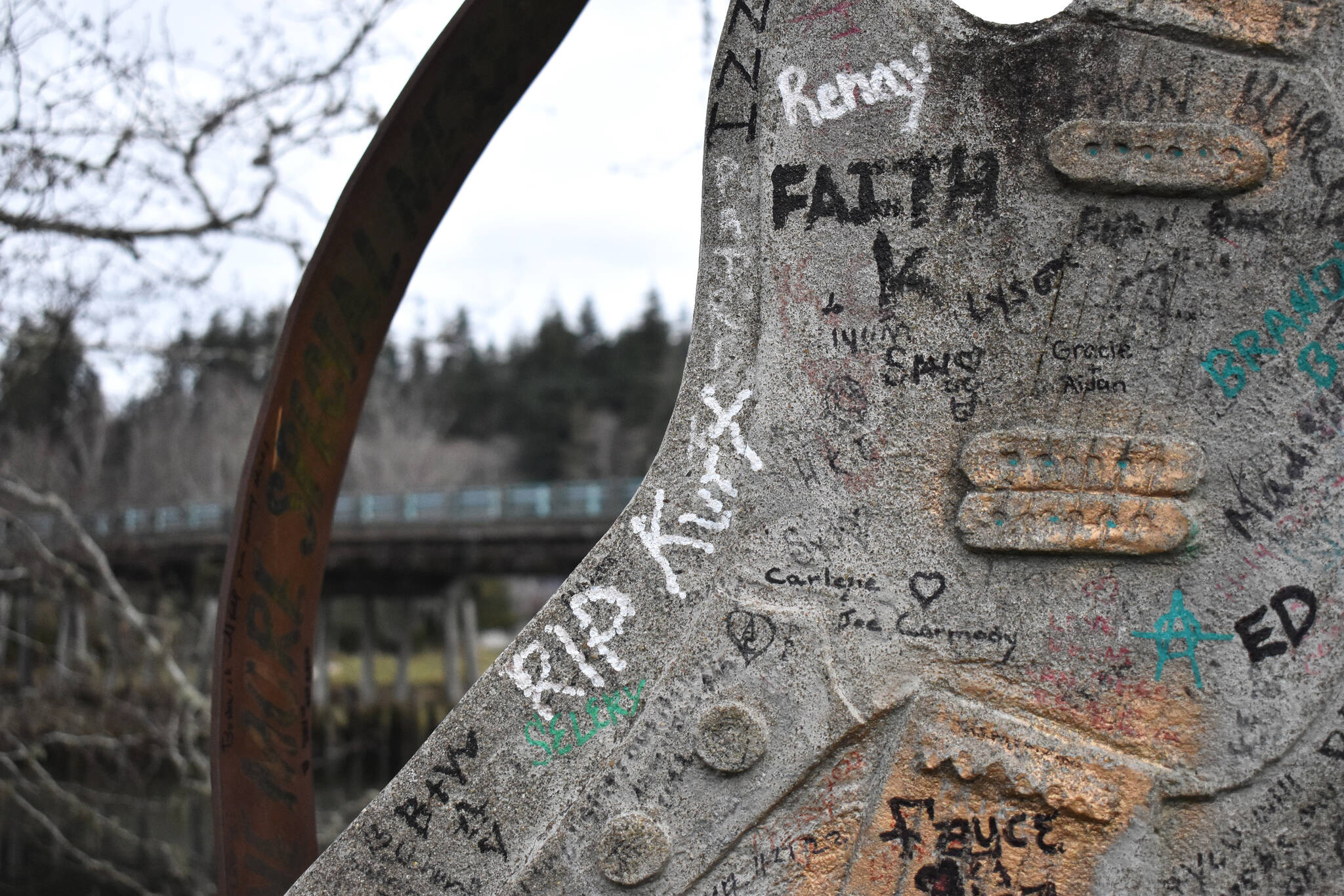 ”RIP Kurt,” is among a large collection of inscriptions that are penned, marked, or spray painted, on the guitar statue at Kurt Cobain Memorial Park, in North Aberdeen. The park, with the bridge seen behind the guitar, sits at the base of the Young Street Bridge. The bridge is slated to come down in the next few years after the city of Aberdeen received $25 million to replace it. (Matthew N. Wells / The Daily World)