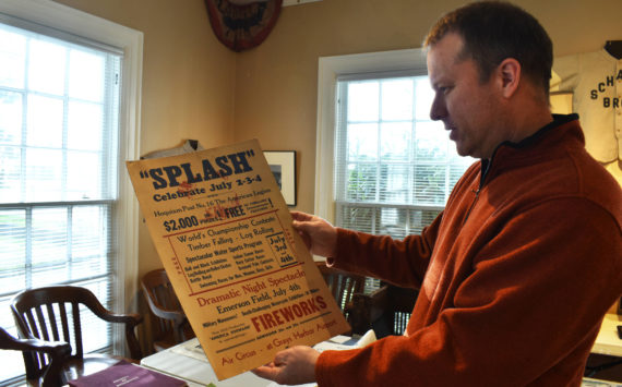 John Larson, Polson Museum's director, holds a Splash Festival poster from 1938. The poster is one of many items of Grays Harbor history that people might find interesting. While the museum is not open for tours until April, Larson and his staff are working hard to make sure it's in the best shape for a public open house April 1. (Matthew N. Wells / The Daily World)