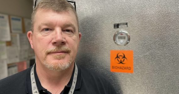 Michael S. Lockett / The Daily World
Grays Harbor County Coroner George Kelley recently started in the position. He stands in front of the office’s fridge on Feb. 8.