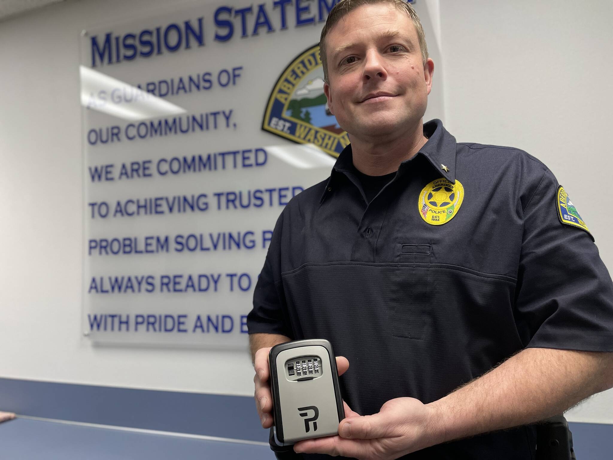 Cmdr. Steve Timmons of the Aberdeen Police Department holds a lockbox of the type that will be available for residents of Aberdeen at no cost through a new program to assist entry for emergency responders in the case of a medical emergency. (Michael S. Lockett / The Daily World)