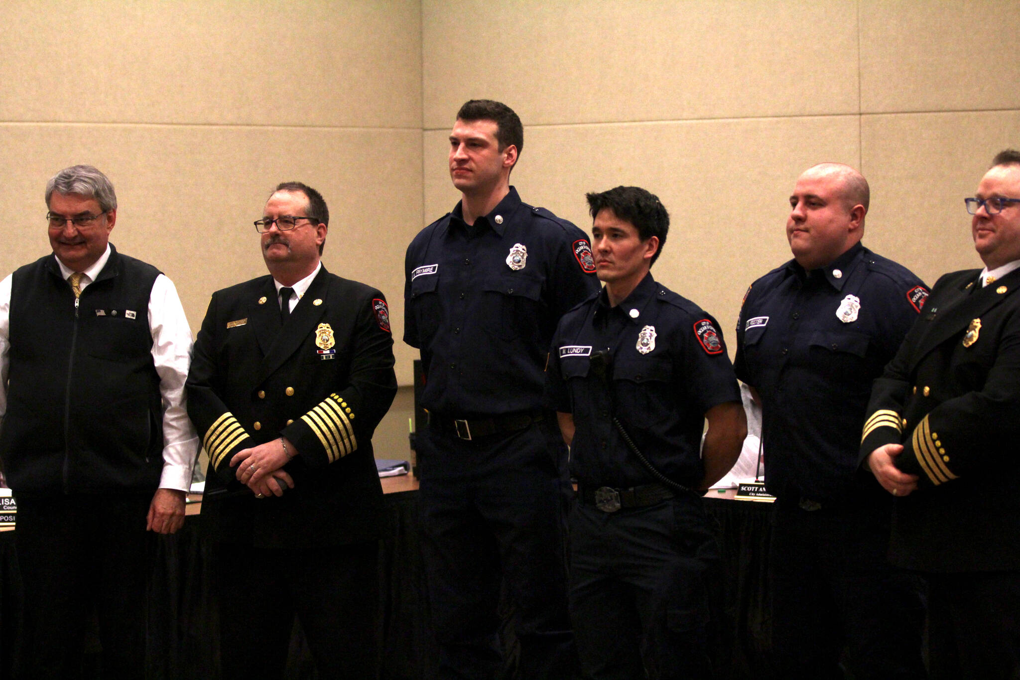 New joins to the Ocean Shores Fire Department stand alongside officers of the department and Ocean Shores Mayor Jon Martin, left, during a swearing-in ceremony on Feb. 13. (Michael S. Lockett / The Daily World)