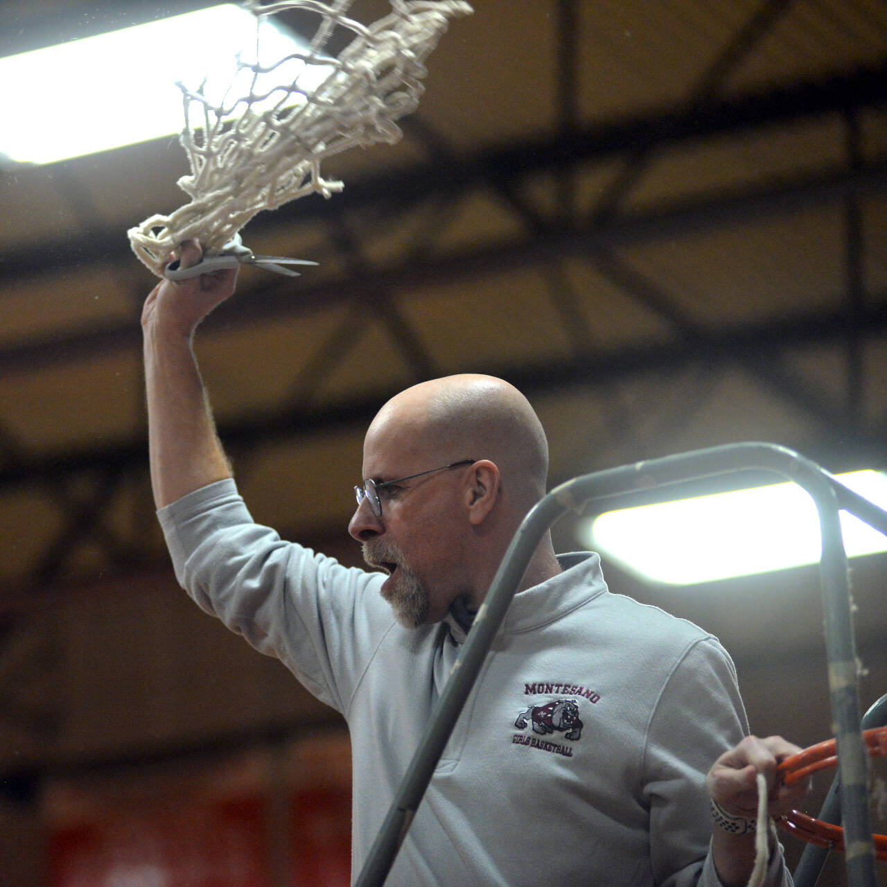 RYAN SPARKS | THE DAILY WORLD Montesano head coach Mark Mansfield cheers after cutting down the net following the Bulldogs’ 72-36 win over Seton Catholic in the 1A District 4 Championship game on Friday at Castle Rock High School.