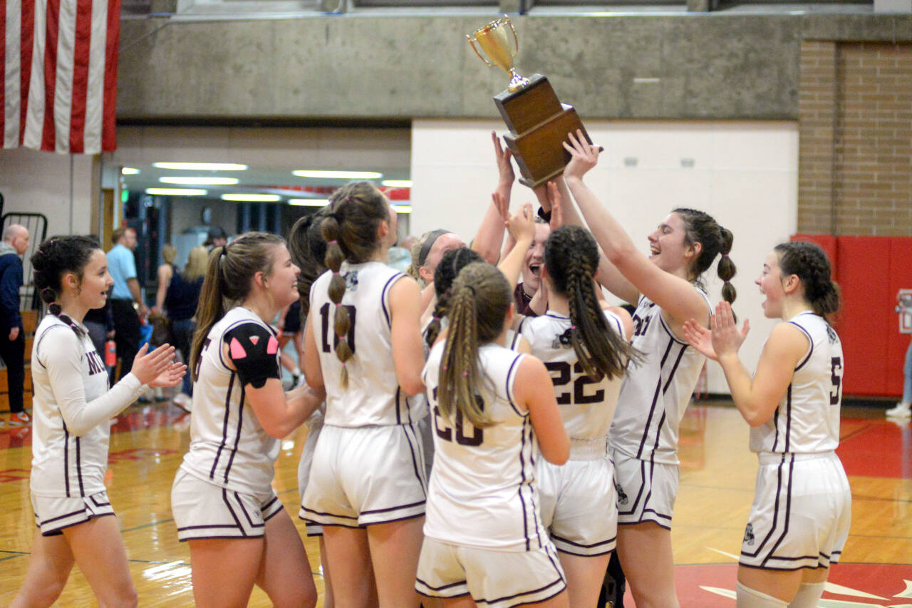 RYAN SPARKS | THE DAILY WORLD The Montesano Bulldogs hoist the 1A District 4 trophy after defeating Seton Catholic 72-36 in the district-championship game on Friday in Castle Rock.