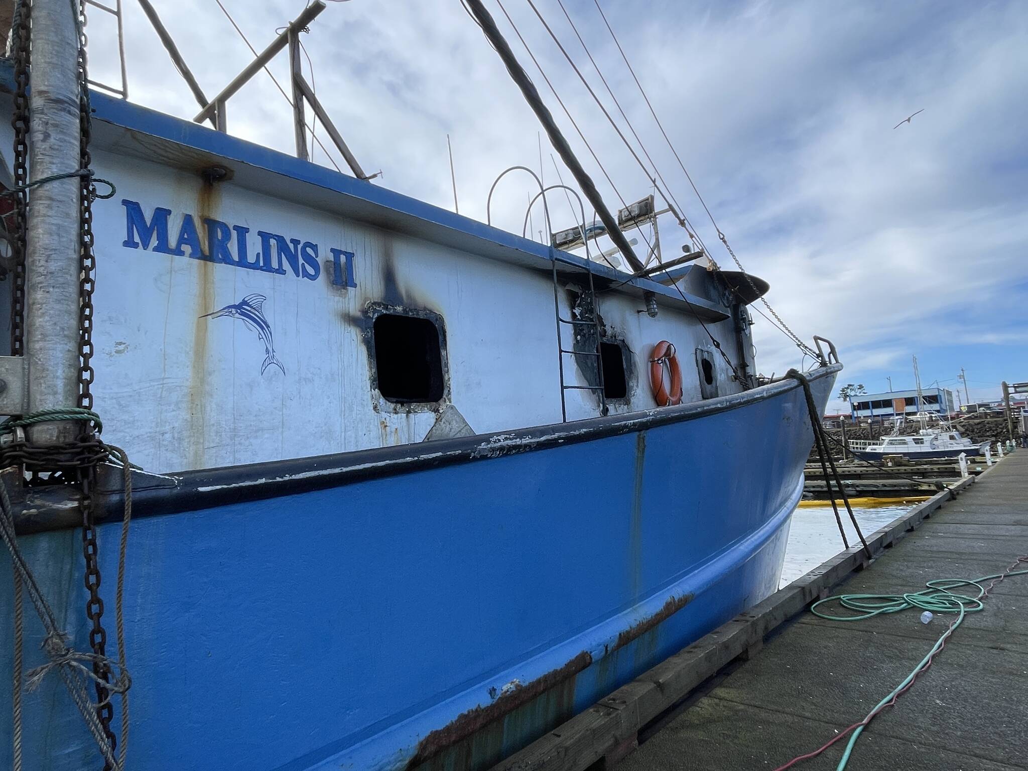 Damage caused by a Thursday fire is visible on the rising from the windows of a fishing vessel moored in the Westport Marina. (Michael S. Lockett / The Daily World)