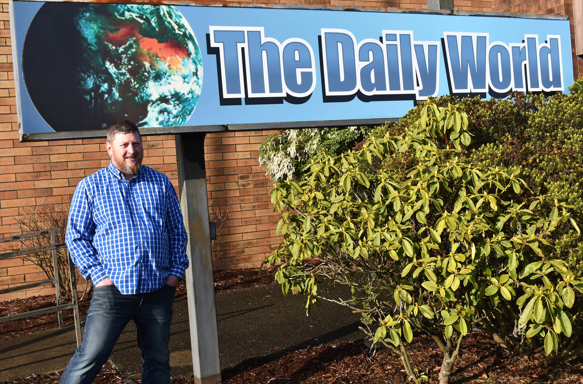 Matthew N. Wells / The Daily World
Terry Ward, the publisher for The Daily World, announced Wednesday morning that Doug Ames — pictured — is the newspaper’s new interim general sales manager. Ames stands in front of The Daily World sign that he himself installed a couple months ago.