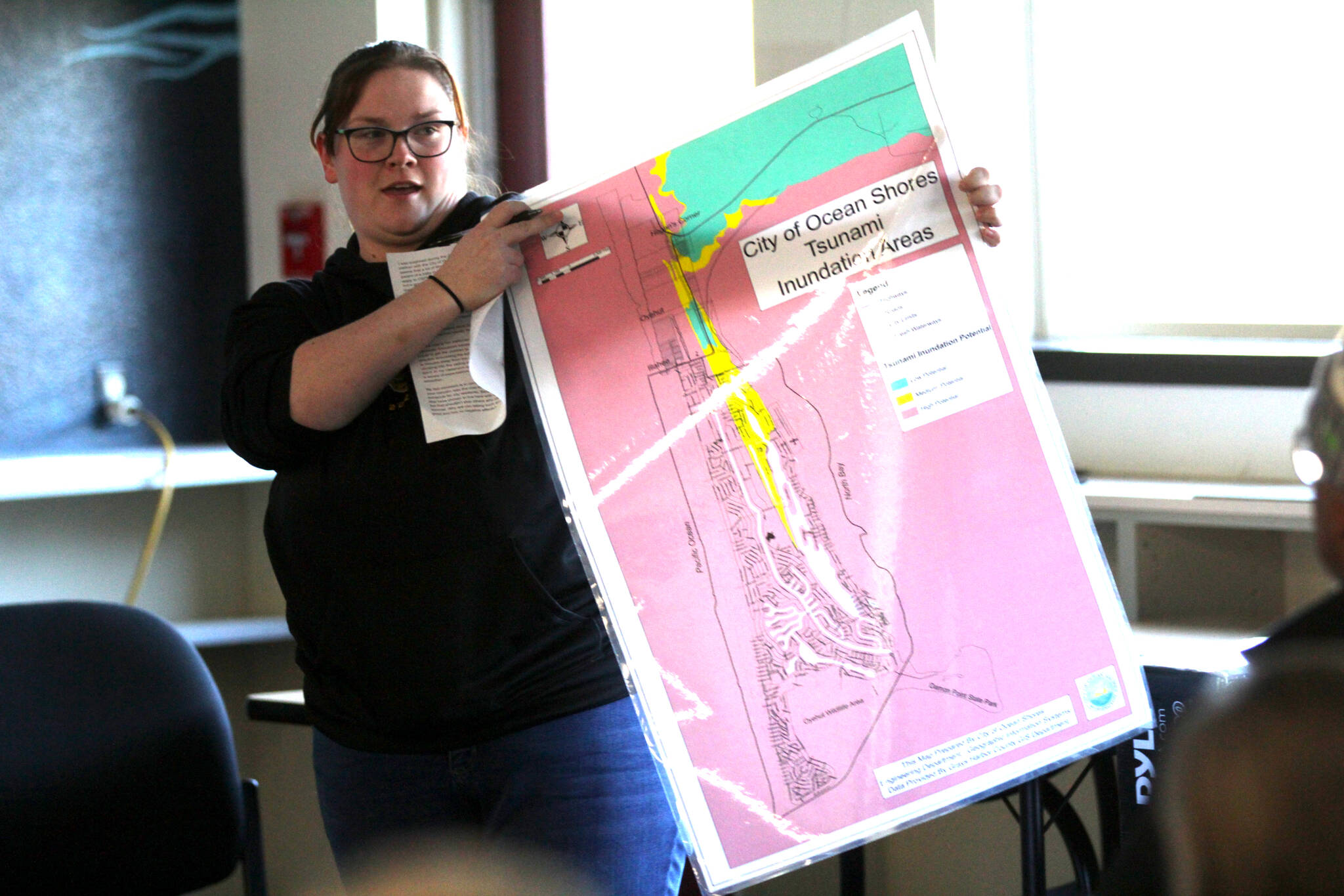 Michael S. Lockett / The Daily World
Ocean Shores Elementary School teacher Haley Stoney holds the inundation map of Ocean Shores during a school board meeting on March 21. The construction of a tsunami tower for the low-lying school has proved contentious with the public.