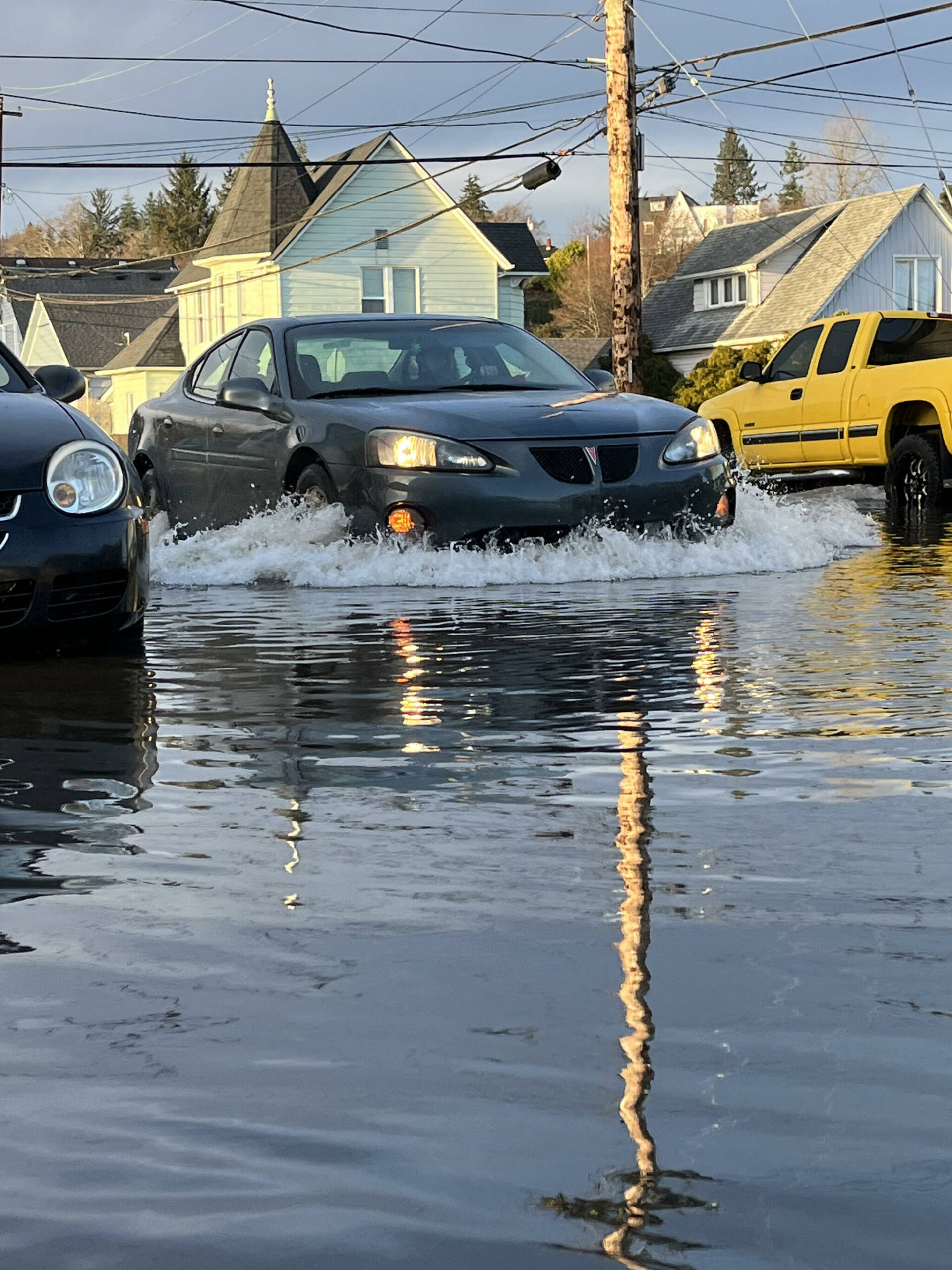 Matthew N. Wells / The Daily World
A Pontiac sedan causes a wake after high tide on Jan. 3, 2022, down E. 1st St., and N. F St., in Aberdeen. Mass flooding throughout Aberdeen and Hoquiam, along with several other environmental factors, caused plenty of cars to turn around to avoid flooding. The Aberdeen-Hoquiam Flood Protection project’s funding is supposed to be bolstered soon by the state. The expected $35.5 million will bring Aberdeen and Hoquiam closer to the construction of the North Shore Levee and the North Shore Levee West segment.