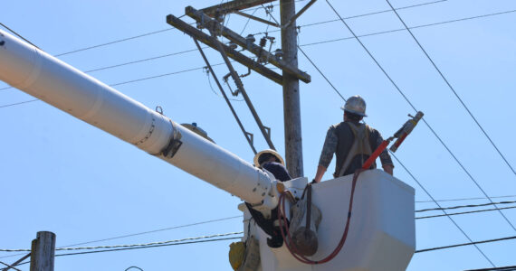 The Daily World file photo
A Grays Harbor PUD lineman inspects damaged lines on a pole in 2021. Multiple outages occurred over the weekend due to gusty weather.