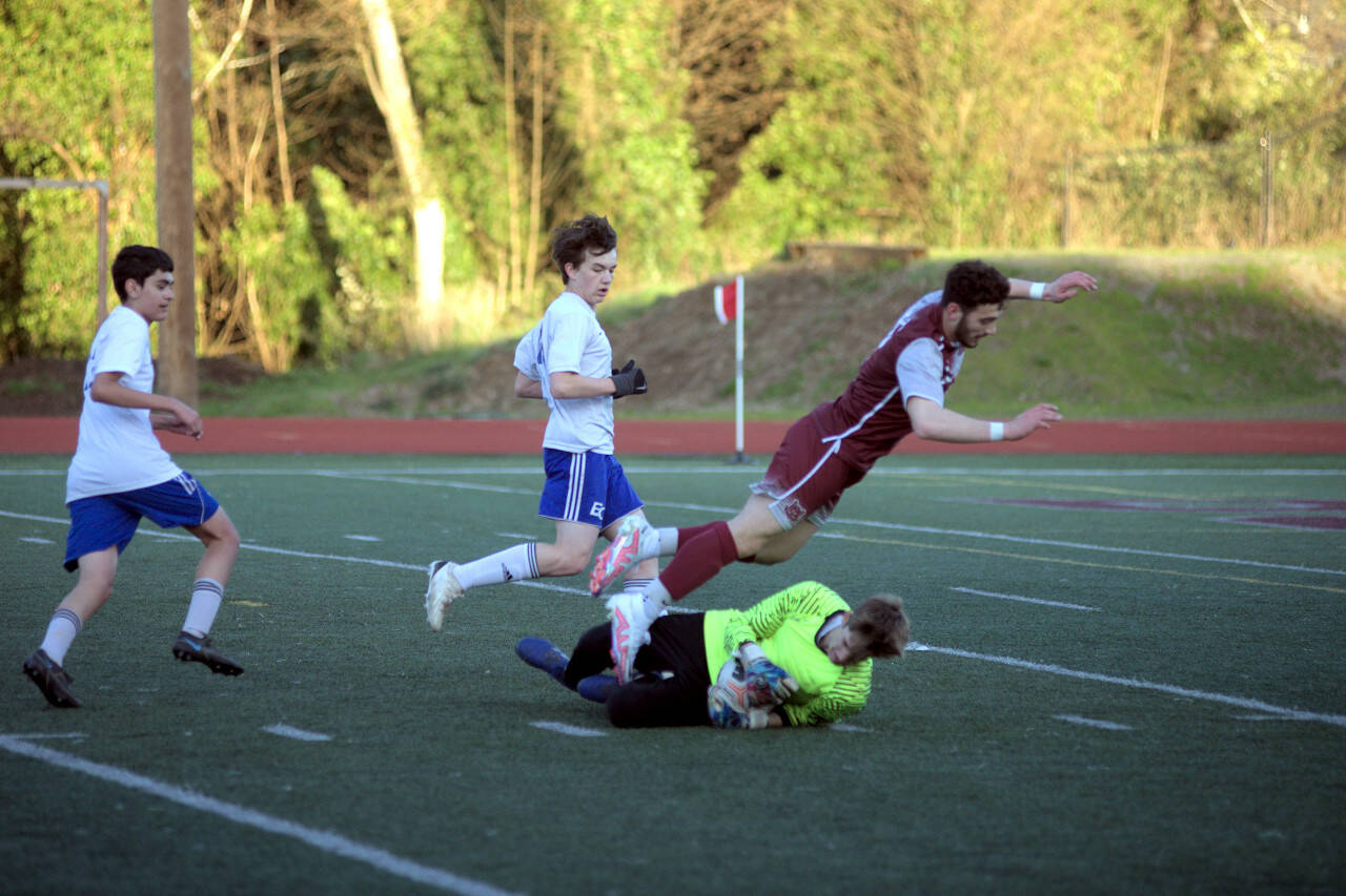 RYAN SPARKS | THE DAILY WORLD Montesano senior Mateo Sanchez leaps over the Eatonville keeper during the Bulldogs’ 4-1 win over the Cruisers on Wednesday in Montesano. Sanchez finished with a hat trick in the match.
