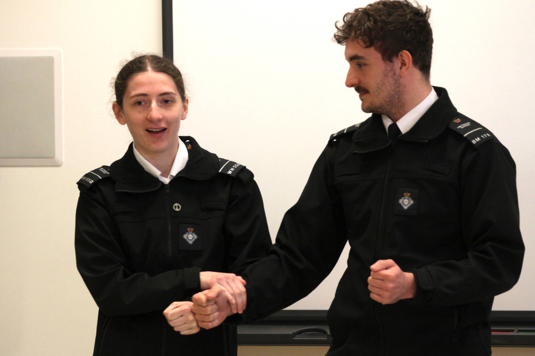 Officer Niamh Donnelly, left, and Officer Daniel Clemson, of His Majesty’s Prison and Probation Service, demonstrate a hold to an international group of corrections personnel at Stafford Creek Corrections Center on April 17 as part of an effort to bring a more human-rights focused approach to corrections. (Michael S. Lockett / The Daily World)