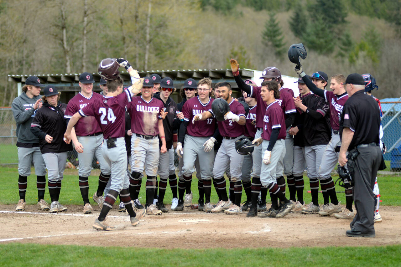 RYAN SPARKS | THE DAILY WORLD Montesanos Bode Poler (24) is greeted by his teammates after hitting a grand slam home run in the fourth inning of the Bulldogs 11-5 win over Elma on Monday at Eagle Field in Elma.