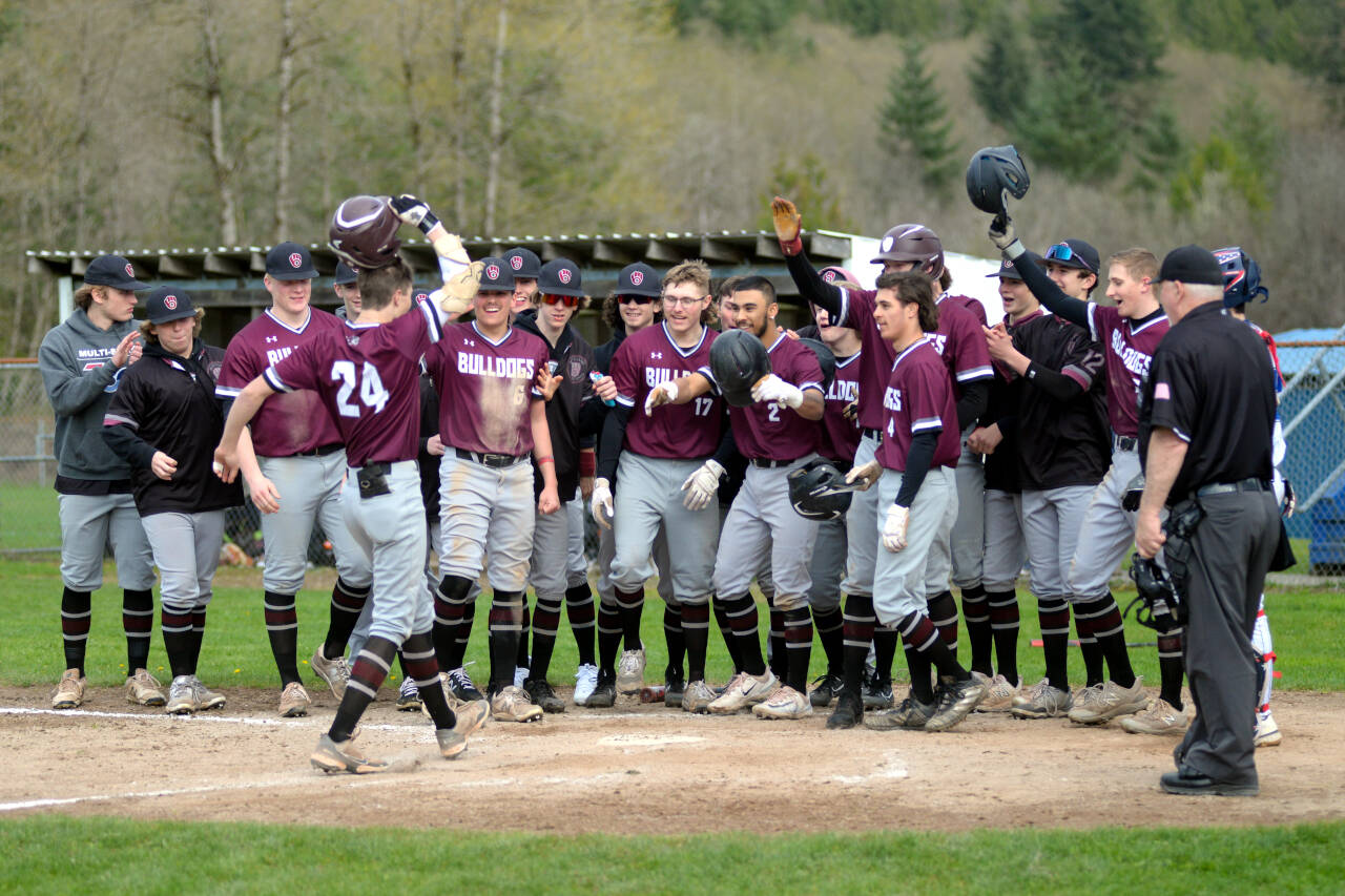 RYAN SPARKS | THE DAILY WORLD Montesano’s Bode Poler (24) is greeted by his teammates after hitting a grand slam home run in the fourth inning of the Bulldogs’ 11-5 win over Elma on Monday at Eagle Field in Elma.