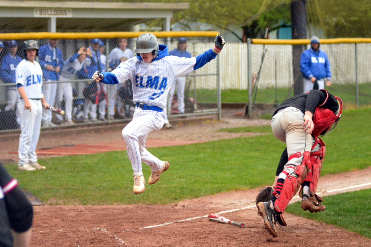 RYAN SPARKS | THE DAILY WORLD Elma’s Ethan Camus (22) leaps away from Tenino catcher Austin Gonia to score a run during the Eagles’ 9-8 win on Friday at Vessey Field in Montesano.
