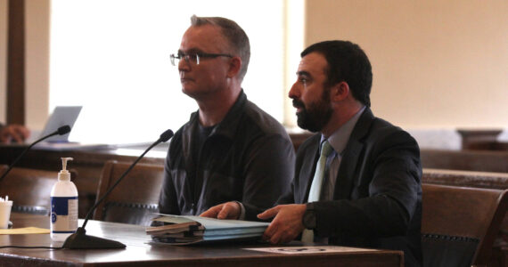 Wade Eric Iseminger, left, appears in his arraignment for multiple charges of child molestation, represented by Luke Laughlin, right, on May 8 in Grays Harbor County Superior Court. (Michael S. Lockett / The Daily World)