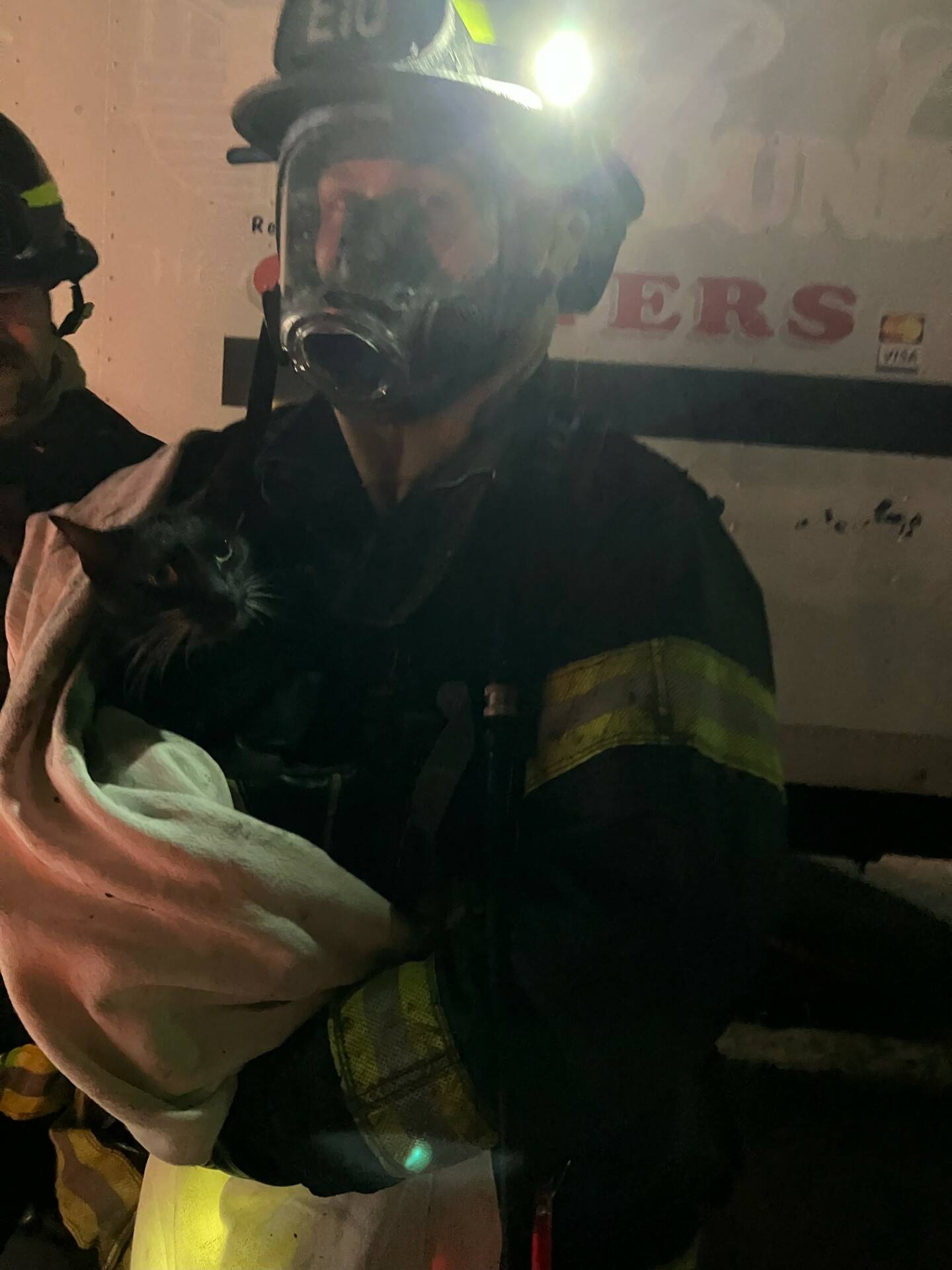 Aberdeen firefighter Alex Bartlett carries a cat rescued from the apartment building fire during a call on May 16. (Courtesy photo / Aberdeen Fire Department)