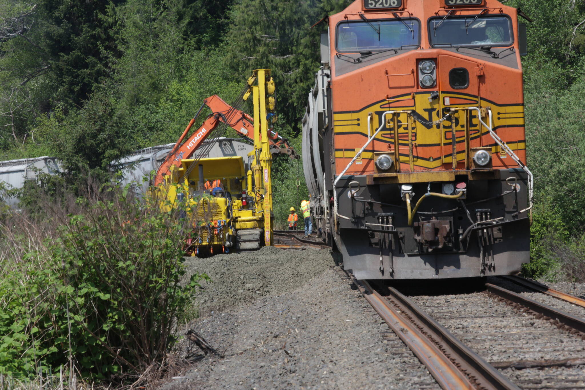 Crews work to rerail train cars carrying soymeal on May 17 on a Puget Sound & Pacific Railroad train that had eight cars derail Sunday in Central Park as a result of thermal misalignment, or heat expansion, of the tracks. (Michael S. Lockett / The Daily World)