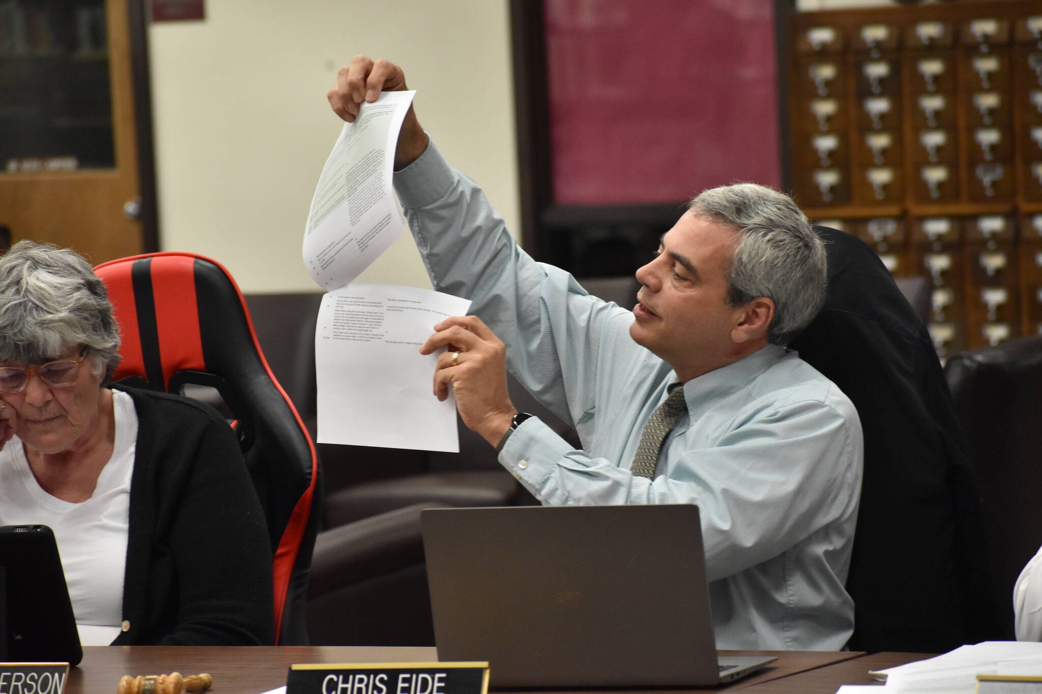 Board member Chris Eide displays spreadsheets Thursday evening containing public opinion gathered at the district’s community meetings on downsizing. (Clayton Franke / The Daily World)