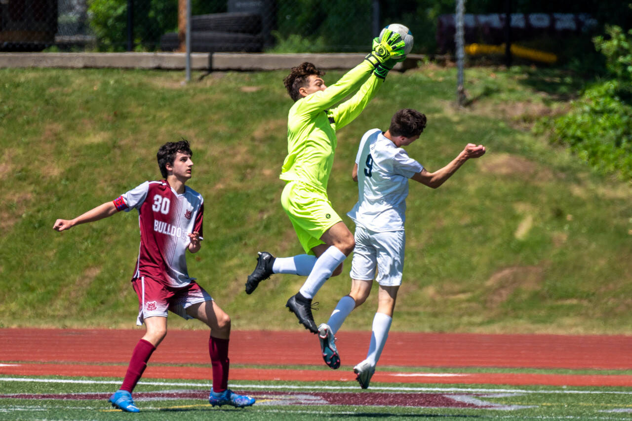 PHOTO BY FOREST WORGUM Montesano goal keeper Jayden McElravy snatches the ball out of the air against Seton Catholic’s Teagan Petracca (9) as Monte’s Spencer Lovell looks on during the Bulldogs’ 2-0 loss in the 1A State Tournament quarterfinals on Saturday in Montesano.