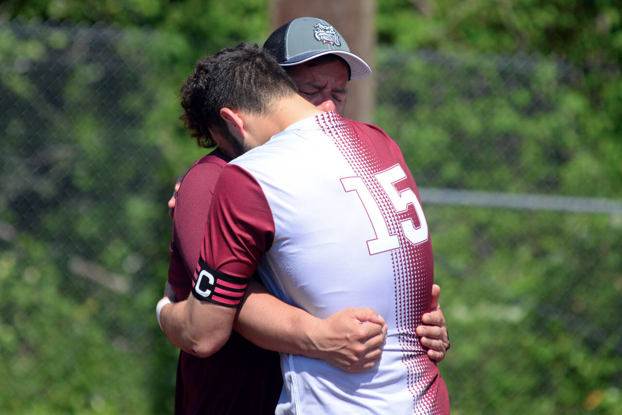 RYAN SPARKS | THE DAILY WORLD Montesano senior co-captain Mateo Sanchez hugs his father and Montesano head coach Fidel Sanchez after a 2-0 loss to Seton Catholic in the 1A State quarterfinal round on Saturday in Montesano.
