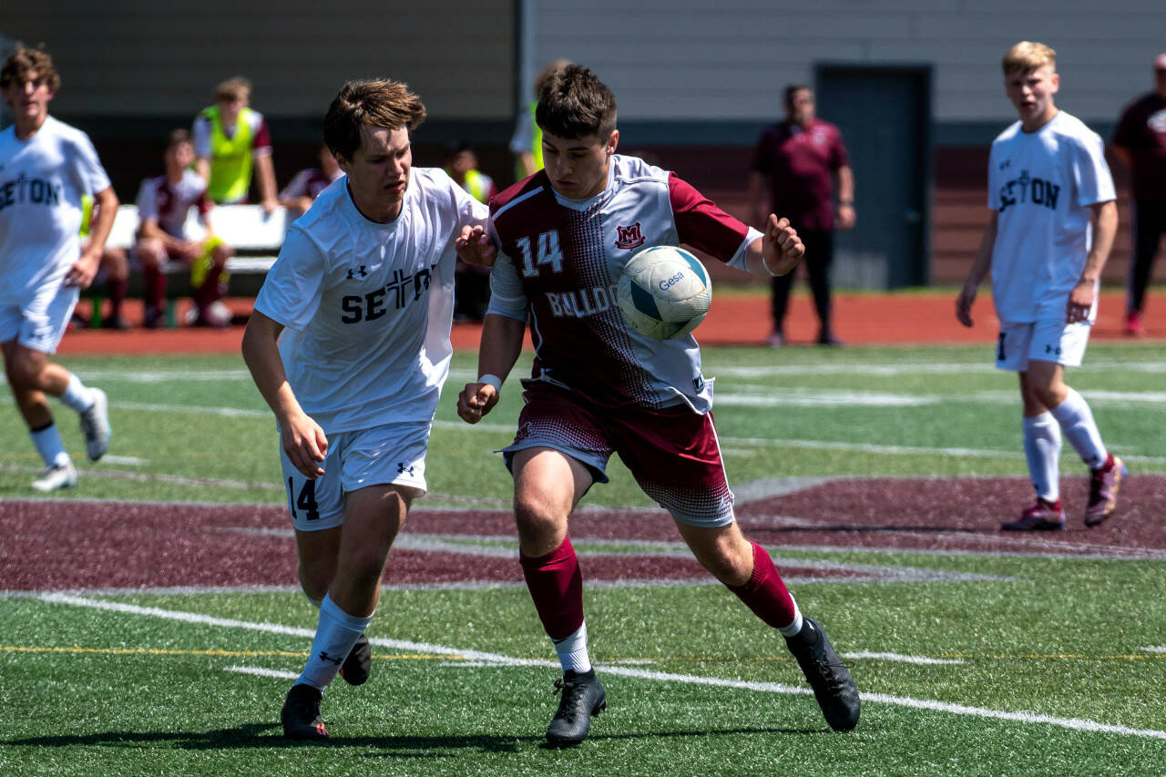 PHOTO BY FOREST WORGUM Montesano forward Felix Romero, right, and Seton Catholic’s Easton Ross compete for possession during the Bulldogs’ 2-0 loss in the 1A State Tournament quarterfinals on Saturday in Montesano.
