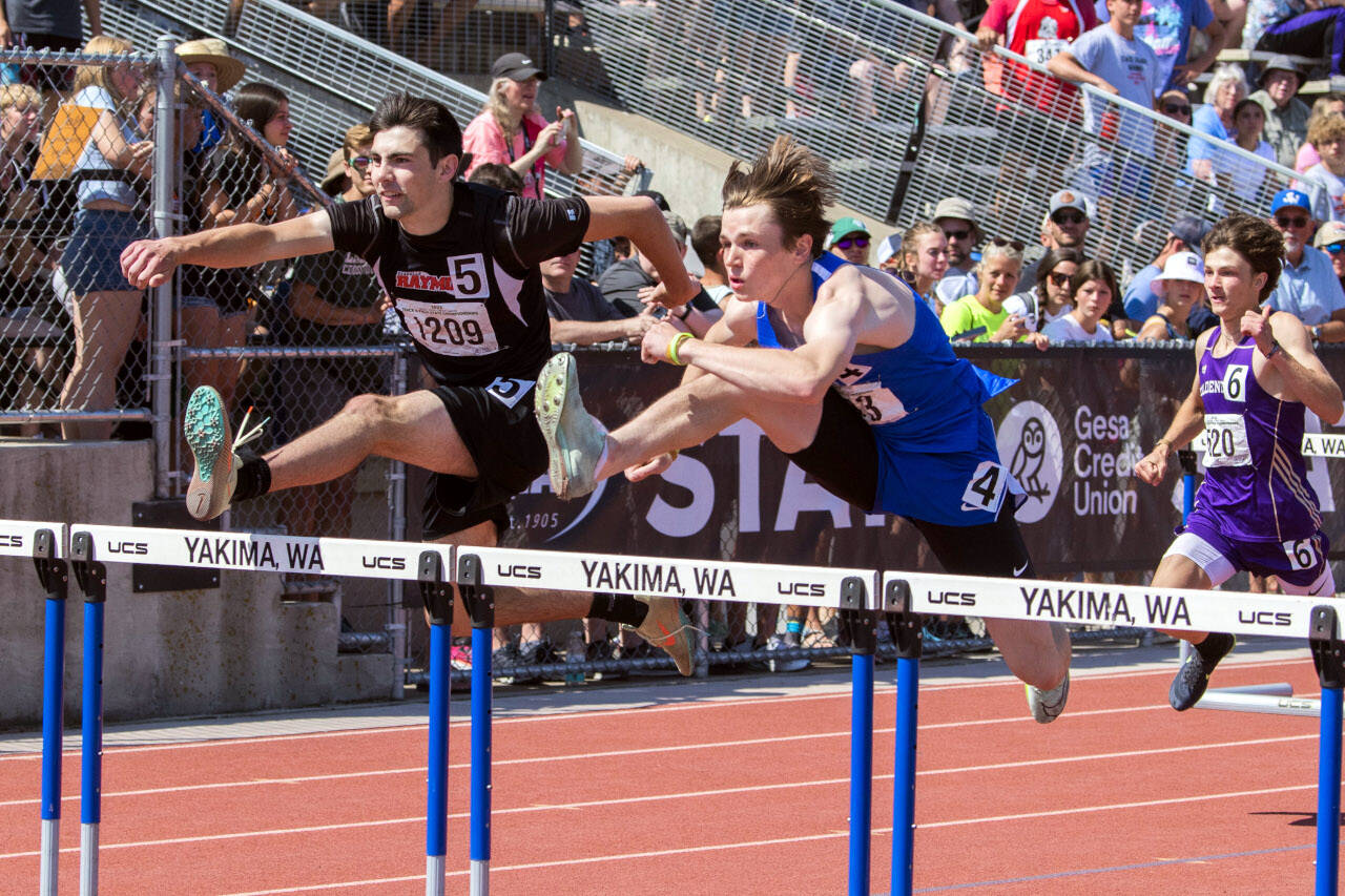 JARED WENZELBURGER | THE CHRONICLE Raymond’s Morgan Anderson, left, races against La Conner’s Tommy Murdock in the boys 110-meter hurdles at the 2B State Championships Saturday in Yakima.