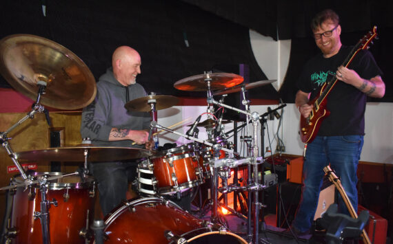 Matthew N. Wells / The Daily World
Larry Cowles, drummer for ‘80s cover band This Way Out, left, hammers the drums as Justin Kautzman, guitarist and singer for Black Shepherd, plays Cowles’ electric guitar Tuesday afternoon inside The Loading Dock, in downtown Aberdeen.