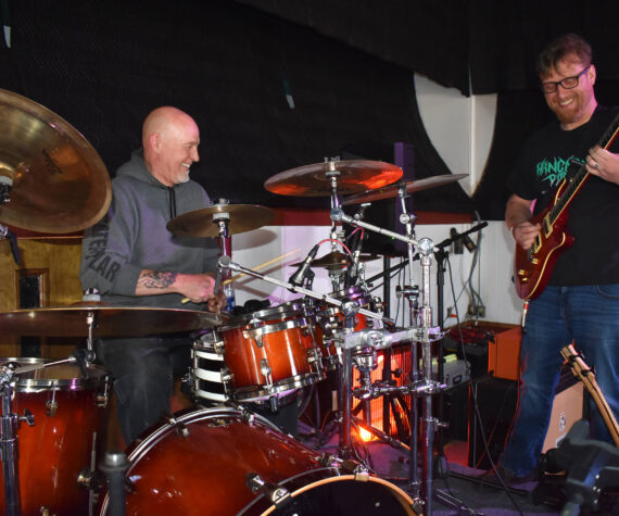 Matthew N. Wells / The Daily World
Larry Cowles, drummer for ‘80s cover band This Way Out, left, hammers the drums as Justin Kautzman, guitarist and singer for Black Shepherd, plays Cowles’ electric guitar Tuesday afternoon inside The Loading Dock, in downtown Aberdeen.