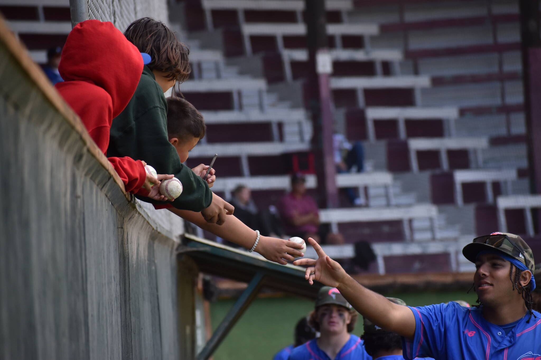 From left: Little leaguers Alonso Aguilar, William Ward and Brayden Jeremiah receive autographs from Josephan Gonzalez.